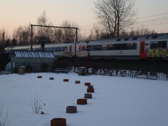 Sous la neige avec le train en toile de fond